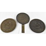 A Japanese bronze hand mirror, length 23.5cm, and a pair of bronze hand mirrors, diameter 13cm (3).