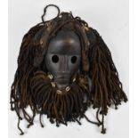 TRIBAL ART; a Dan mask with hair and beard adorned with cowrie shells, height approx 30cm.