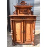 A late 19th century Continental walnut cabinet with shelf above frieze drawer and panel door flanked