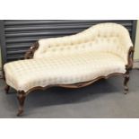 A Victorian carved walnut framed button upholstered chaise longue with serpentine seat and