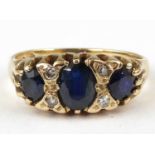 A 9ct gold sapphire and diamond ring, three oval cut sapphires separated by two rows of two tiny