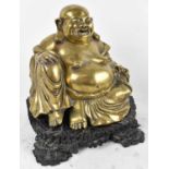 A large Chinese brass figure of Hotei (Buddha) on carved hardwood base, total height 32cm.
