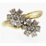 An 18ct gold diamond double flower head crossover ring, each flower set with central claw set