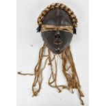 TRIBAL ART; a Dan mask, the headdress adorned with cowrie shells, height 30cm.
