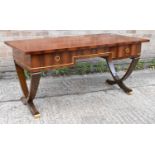 A walnut veneered French inspired three drawer writing table raised on shaped supports, width