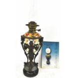 A late 19th century oil lamp with ornate figural mounts, lacking shade, height to top of chimney