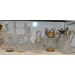 A set of three cut glass decanters with hallmarked silver collars, three assorted claret jugs with