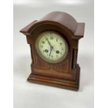 An Edwardian mahogany and inlaid eight day mantel clock with Arabic numerals to the circular dial,