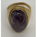 A substantial yellow metal purple agate oval set gentleman's ring, size V, approx. 10.6g.