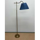 A brass floor lamp with angled arm, turned central column and simple turned foot, height 155cm.
