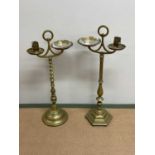 Two brass ashtrays on stands with glass ashtrays, height of taller 77cm.