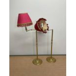 A pair of brass floor lamps with pleated shades above adjustable arms, fluted central columns and
