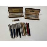 A collection of pens including two cased Parkers and various others.