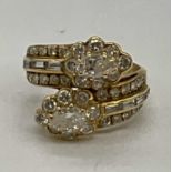 A yellow metal and diamond set crossover ring, each main section set with a pear shaped diamond each