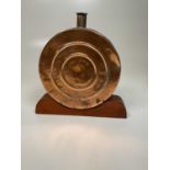 A decorative copper flask on wooden plinth, 34 x 29cm.