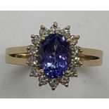 A 14ct yellow gold tanzanite and diamond oval cluster ring, size M1/2, approx. 3.6g. Condition