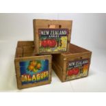 Three vintage wooden fruit crates with colourful labels.