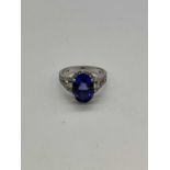 An 18ct white gold tanzanite and diamond ring, the oval tanzanite weighing 5.49cts within a