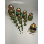 A set of twenty Russian nesting dolls with hand painted trees and buildings, also with a hand