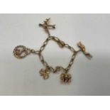 A 9ct yellow gold rope link charm bracelet, with charms including greyhounds, monkeys, aeroplane