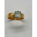 An 18ct broad yellow gold ring set with pale blue stone size Y1/2, approx. 6.3g.