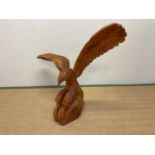 A large contemporary carved wooden sculpture modelled as an eagle, width approx. 90cm.