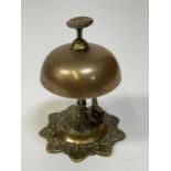 An early 20th century brass push button bell with rising hinged clapper striking on the exterior