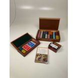 An ostrich skin cased set of gaming chips, a cased set of playing cards, dice and gaming chips and