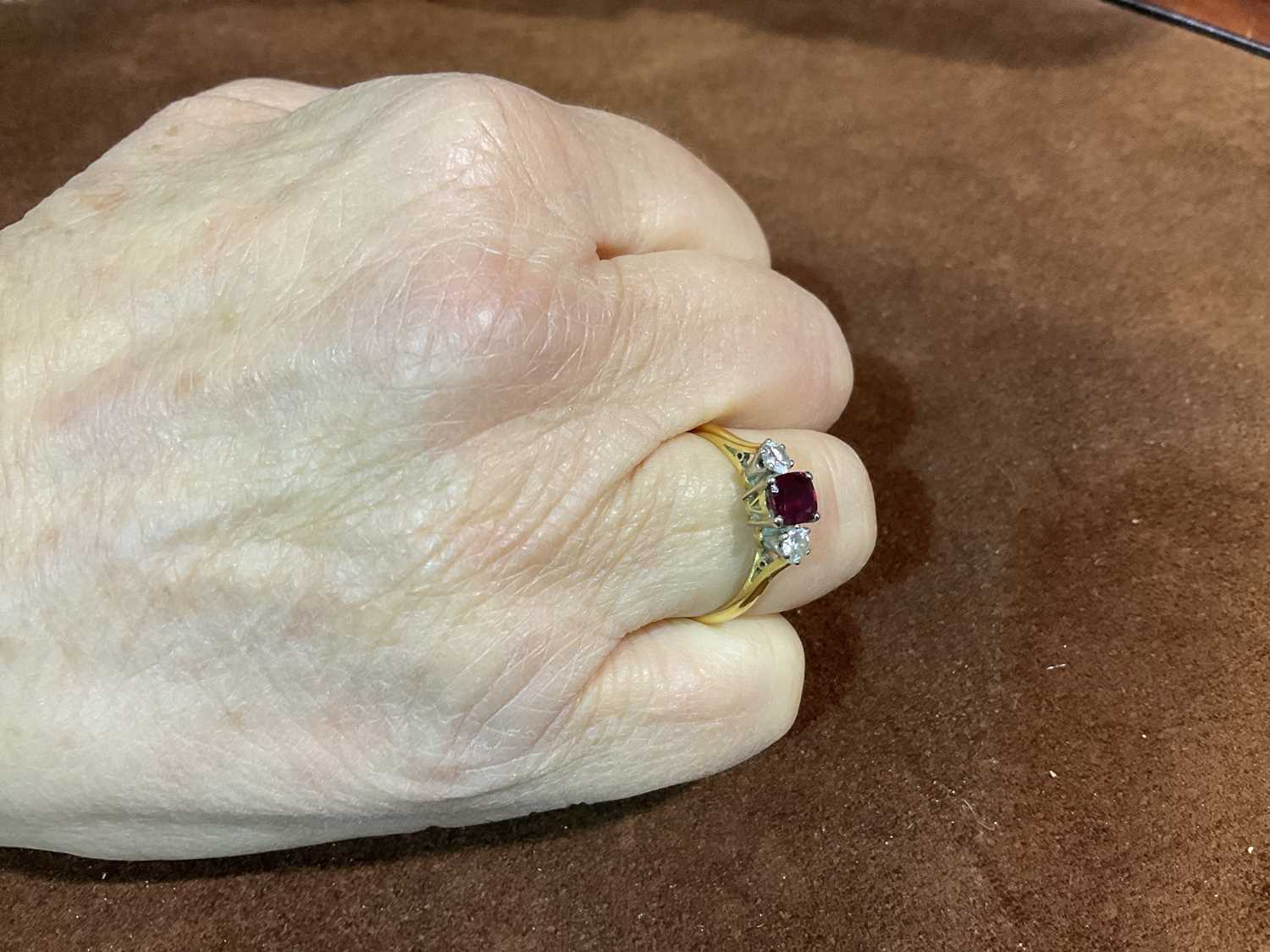 An 18ct yellow gold ruby and diamond three stone ring, the central cushion cut ruby flanked by - Image 6 of 6