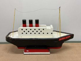 A naive painted wooden model of the Queen Mary, length 86cm, width 27cm, height 62 cm.