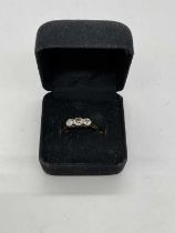 A yellow metal three stone graduated diamond ring, marks rubbed, size K 1/2, approx. 2g.
