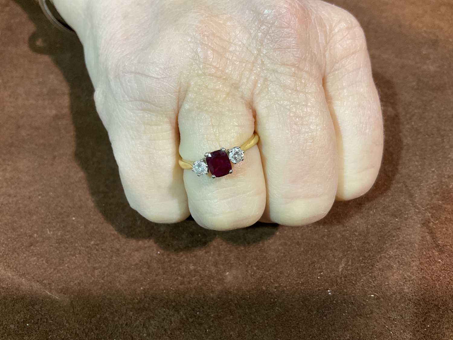 An 18ct yellow gold ruby and diamond three stone ring, the central cushion cut ruby flanked by - Image 5 of 6