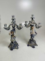 A pair of Meissen candelabra, each with three scrolling arms encrusted with flowers and leaves and