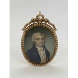 X An early 19th century oval portrait miniature set in seed pearl adorned yellow metal frame with