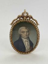 X An early 19th century oval portrait miniature set in seed pearl adorned yellow metal frame with