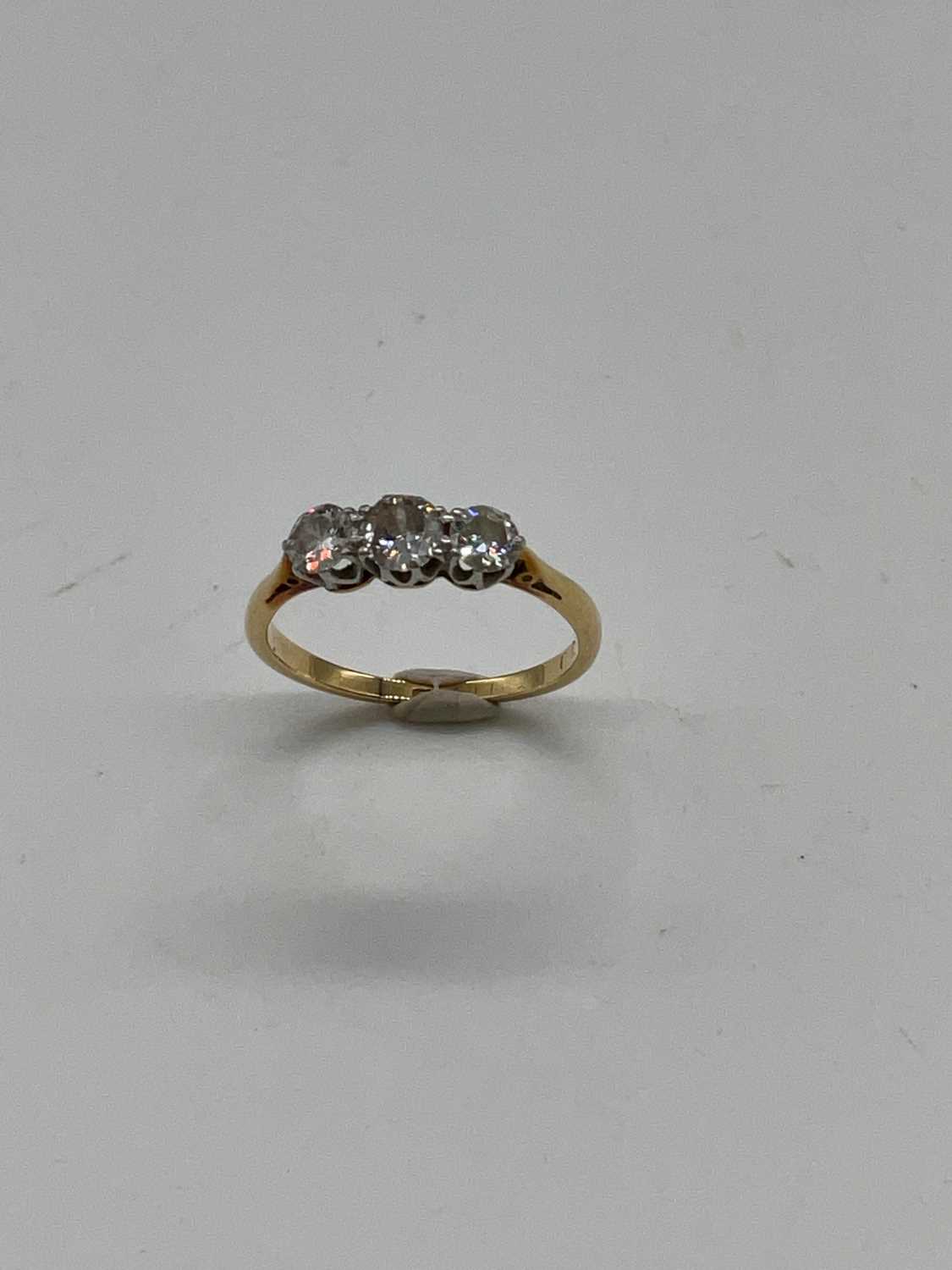 A yellow metal three stone graduated diamond ring, marks rubbed, size K 1/2, approx. 2g. - Image 2 of 4