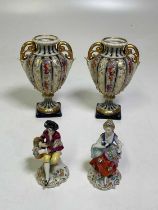A pair of Continental porcelain vases decorated with fruit and vines and scrolled handles, height