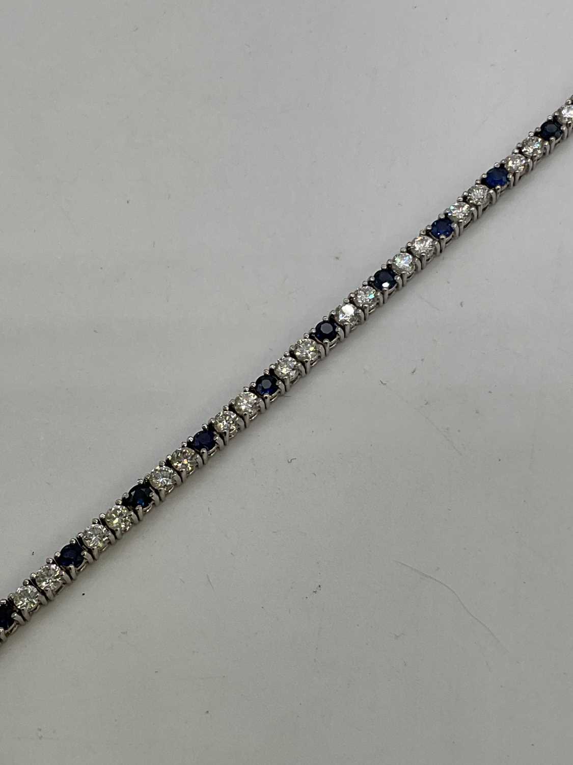 An 18ct white gold diamond and sapphire line bracelet formed of thirty-five round brilliant cut - Image 2 of 3