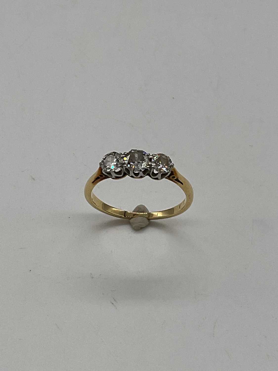 A yellow metal three stone graduated diamond ring, marks rubbed, size K 1/2, approx. 2g. - Image 3 of 4