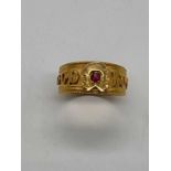 An 18ct yellow gold 'Good Luck' ring set with a ruby, size L, approx. 3.25g. Condition Report: The