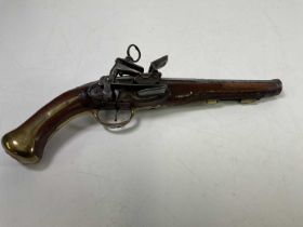 An early 19th century flintlock pistol with brass and steel furniture, belt loop and cannon