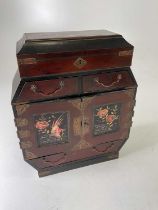 An Oriental inlaid and lacquered table top cabinet with doors enclosing four drawers decorated