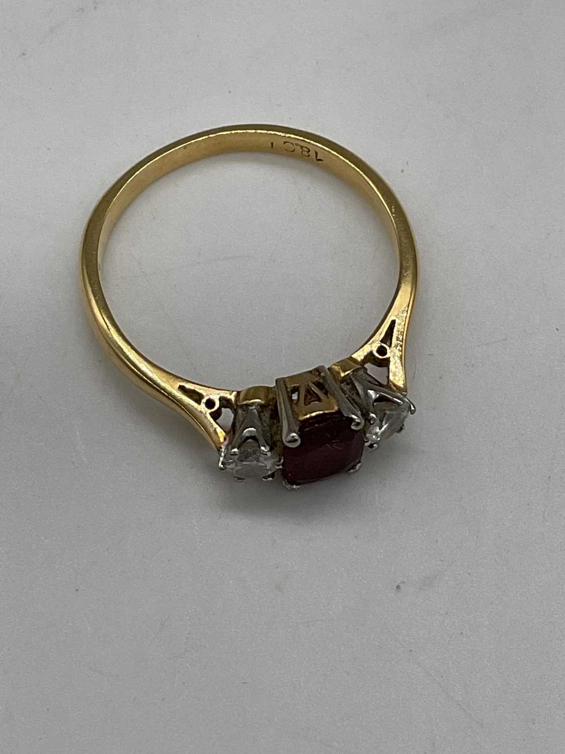 An 18ct yellow gold ruby and diamond three stone ring, the central cushion cut ruby flanked by - Image 2 of 6