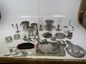 A quantity of silver plate comprising ice buckets, trays, candle holders, wine stoppers, flatware