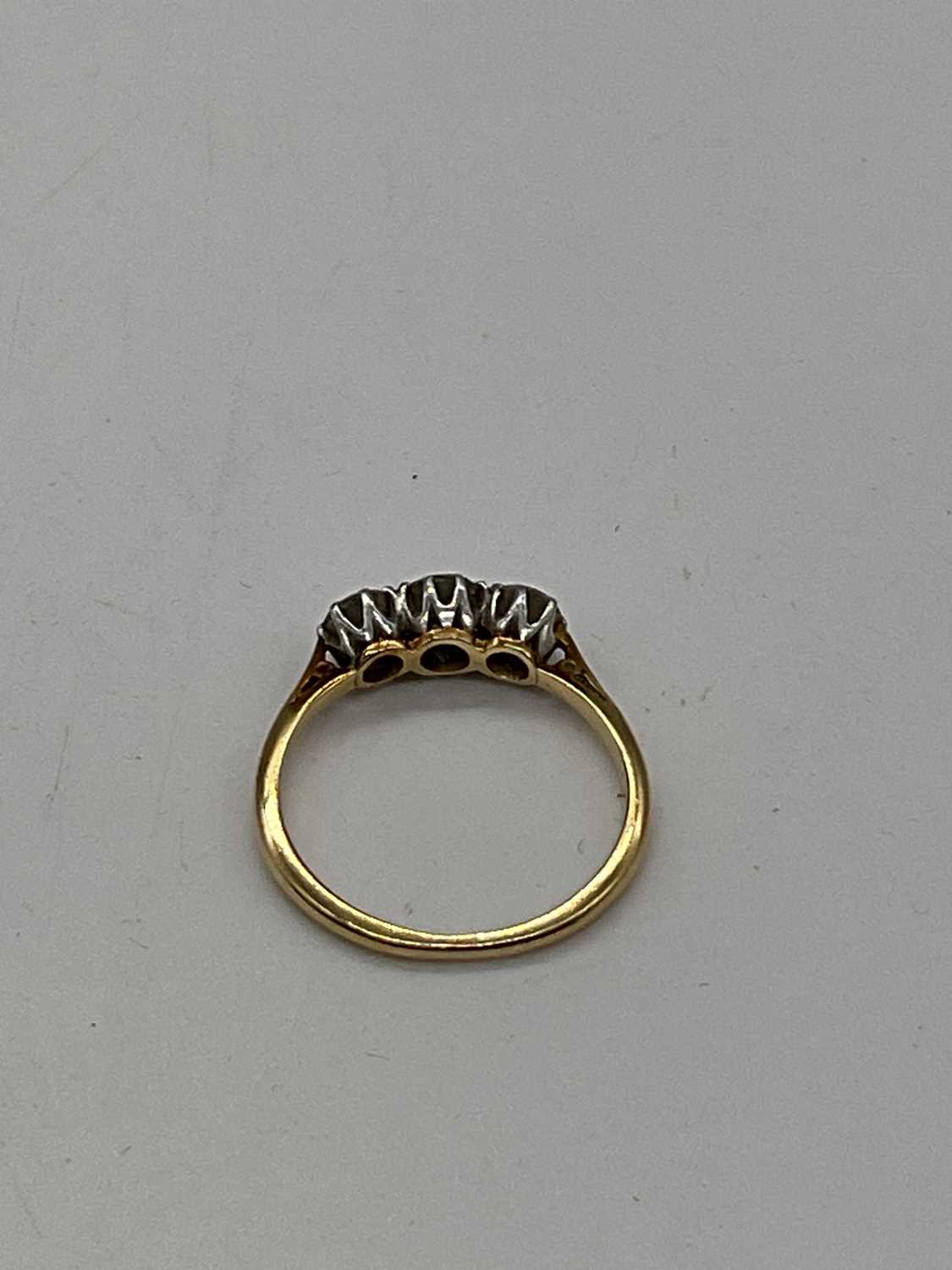 A yellow metal three stone graduated diamond ring, marks rubbed, size K 1/2, approx. 2g. - Image 4 of 4