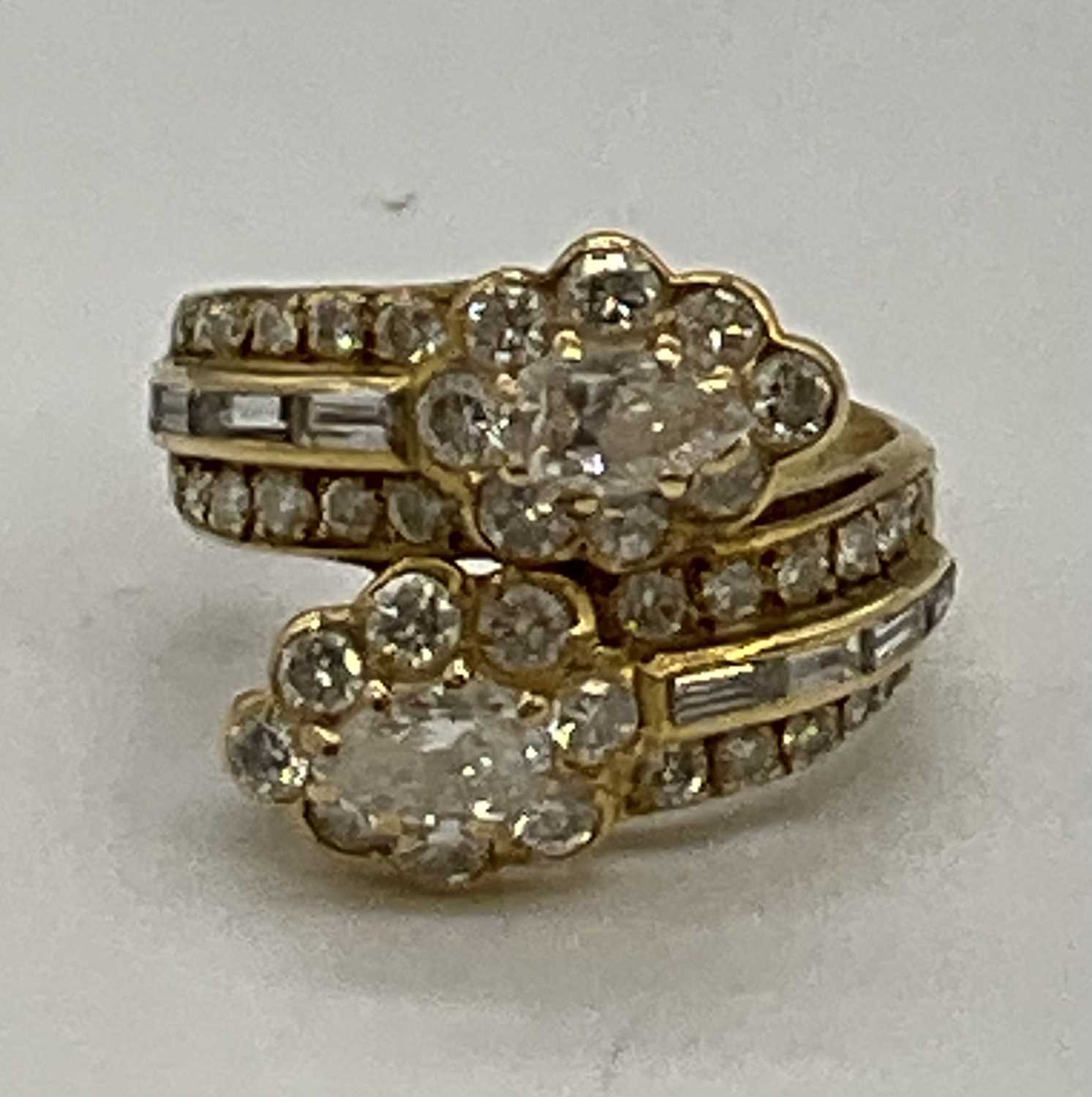 A yellow metal and diamond set crossover ring, each main section set with a pear shaped diamond each