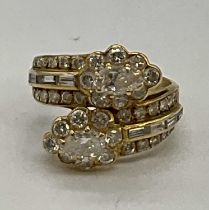 A yellow metal and diamond set crossover ring, each main section set with a pear shaped diamond each