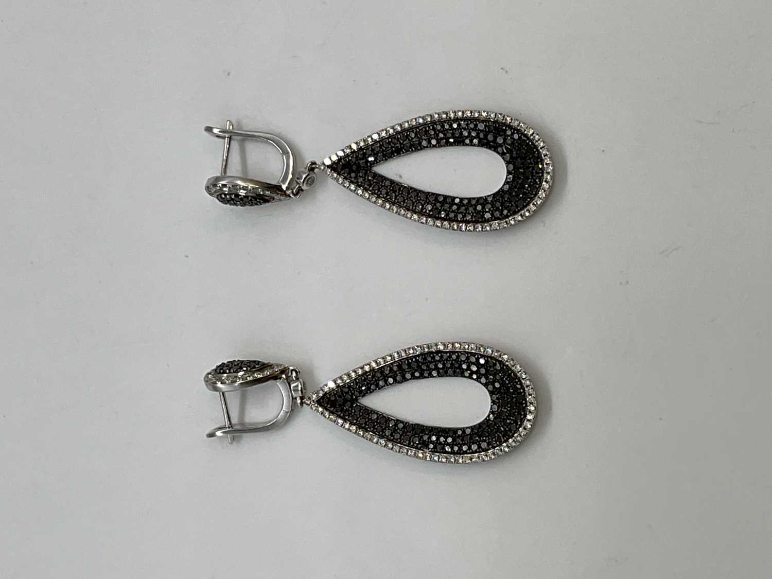 A pair of 18ct white gold black and white diamond set pierced drop earrings combined set with two