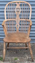 An elm seated Windsor wheel back elbow chair on turned supports.