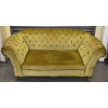 A Victorian green buttoned upholstered double drop end sofa on bun feet.